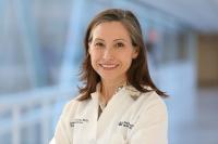 Headshot of Dr. Christine Kim Garcia, MD with a blurred backdrop of a hospital